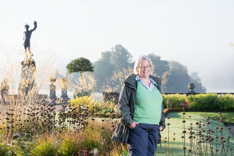 Carol Adams - Head of Horticulture and Biodiversity at Trentham Estate standing  in the Italian Gardens with a view of a statue of Perseus and the lake in the background
